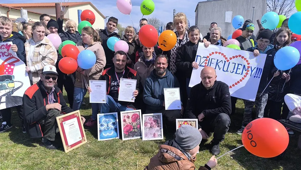 Pamiątkowe zdjęcie grupowe wychowanków ośrodka i kierowców z ufundowanymi upominkami.